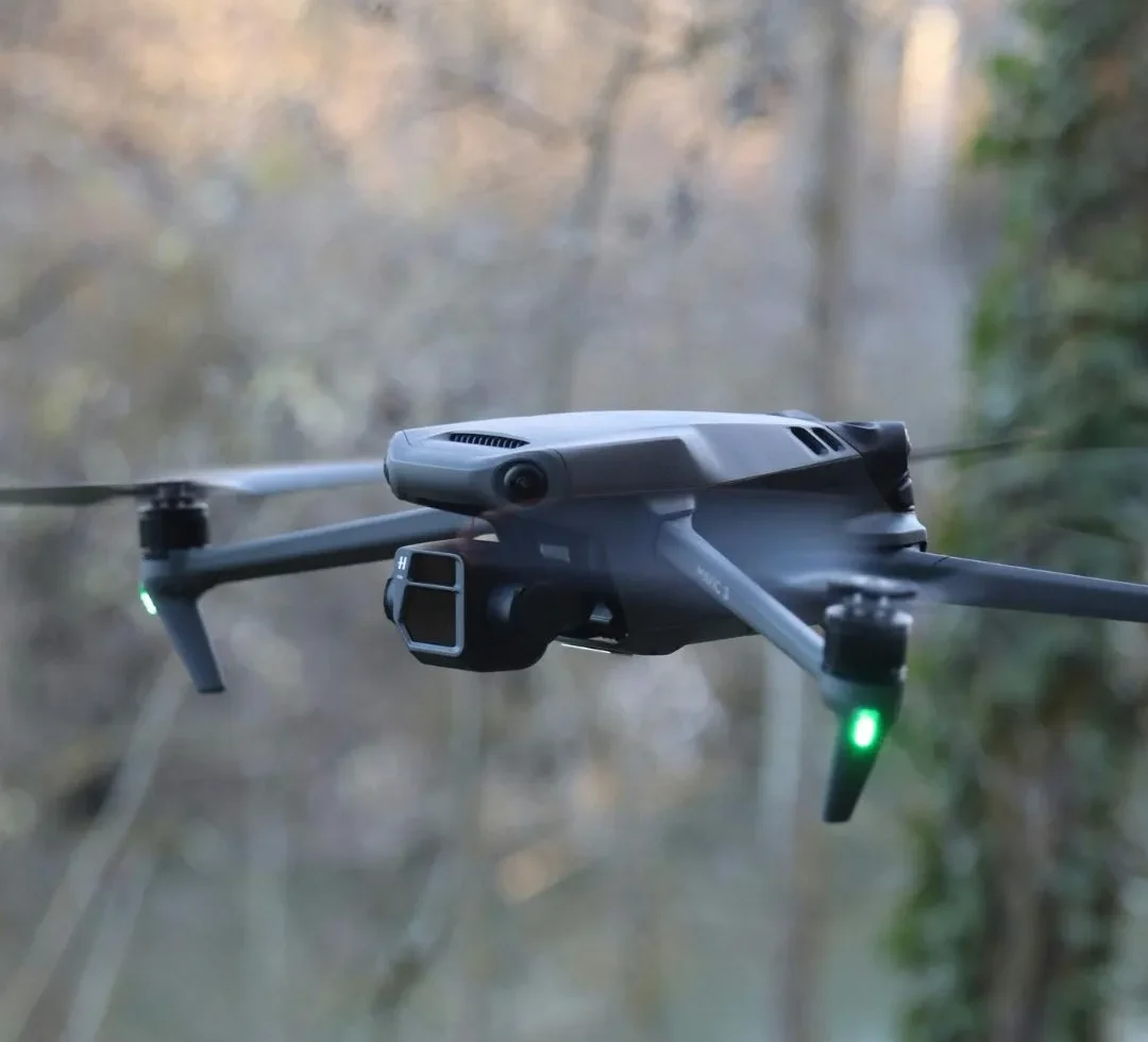 Drone en vol réalisant une captation aérienne pour l’observation et l’analyse d’un site.